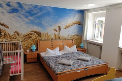 Schlafzimmer mit Doppelbett, Bett in Rennauto-Optik und Babybett